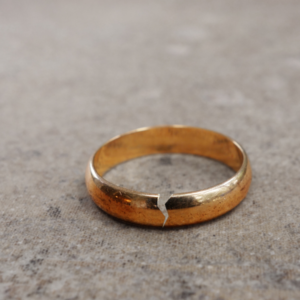 a golden wedding band that has a crack in it
